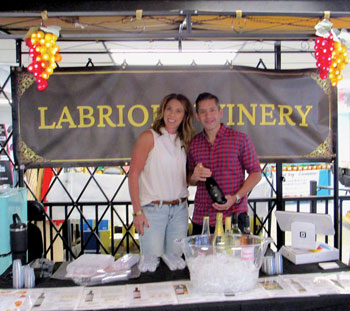 Rug Phatak, general manager, and Kathy Goulder in front of the Labriola Winery kiosk at BITS.