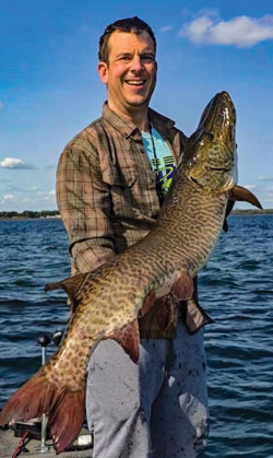 Luke Wholey with a fresh-from-the-water catch–a muskellunge (“musky”).